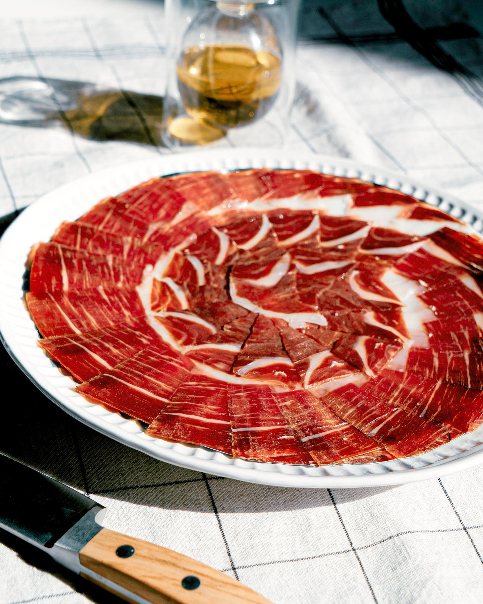 Jamón ibérico de bellota cortado a cuchillo y servido en plato en Bodegas del Desierto
